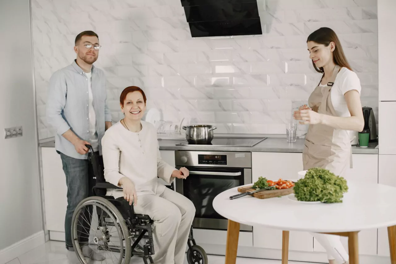 NDIS participant receiving household task support in kitchen with support worker