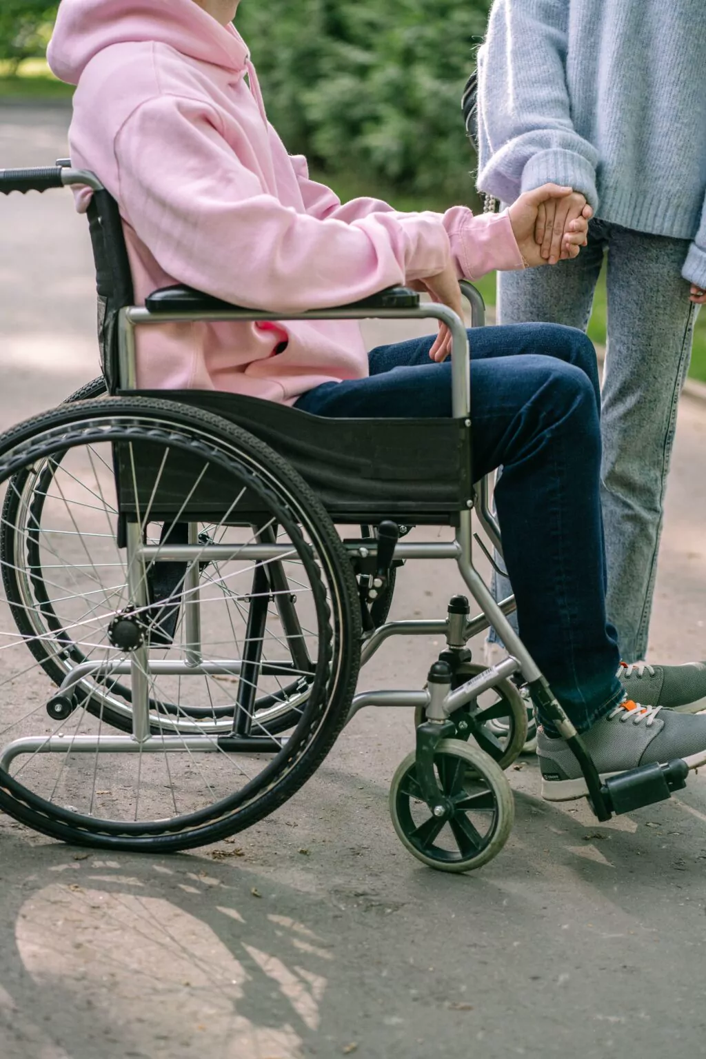 A person in a wheelchair with a companion walking beside them