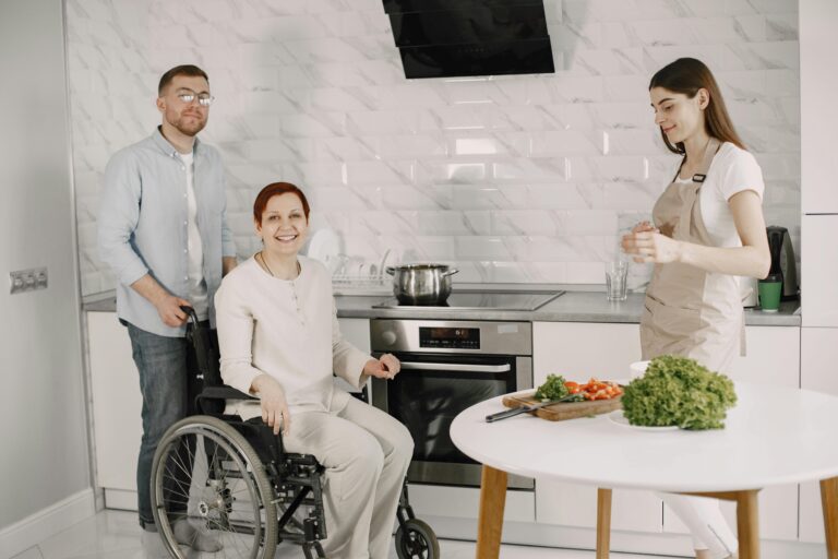 NDIS participant receiving household task support in kitchen with support worker