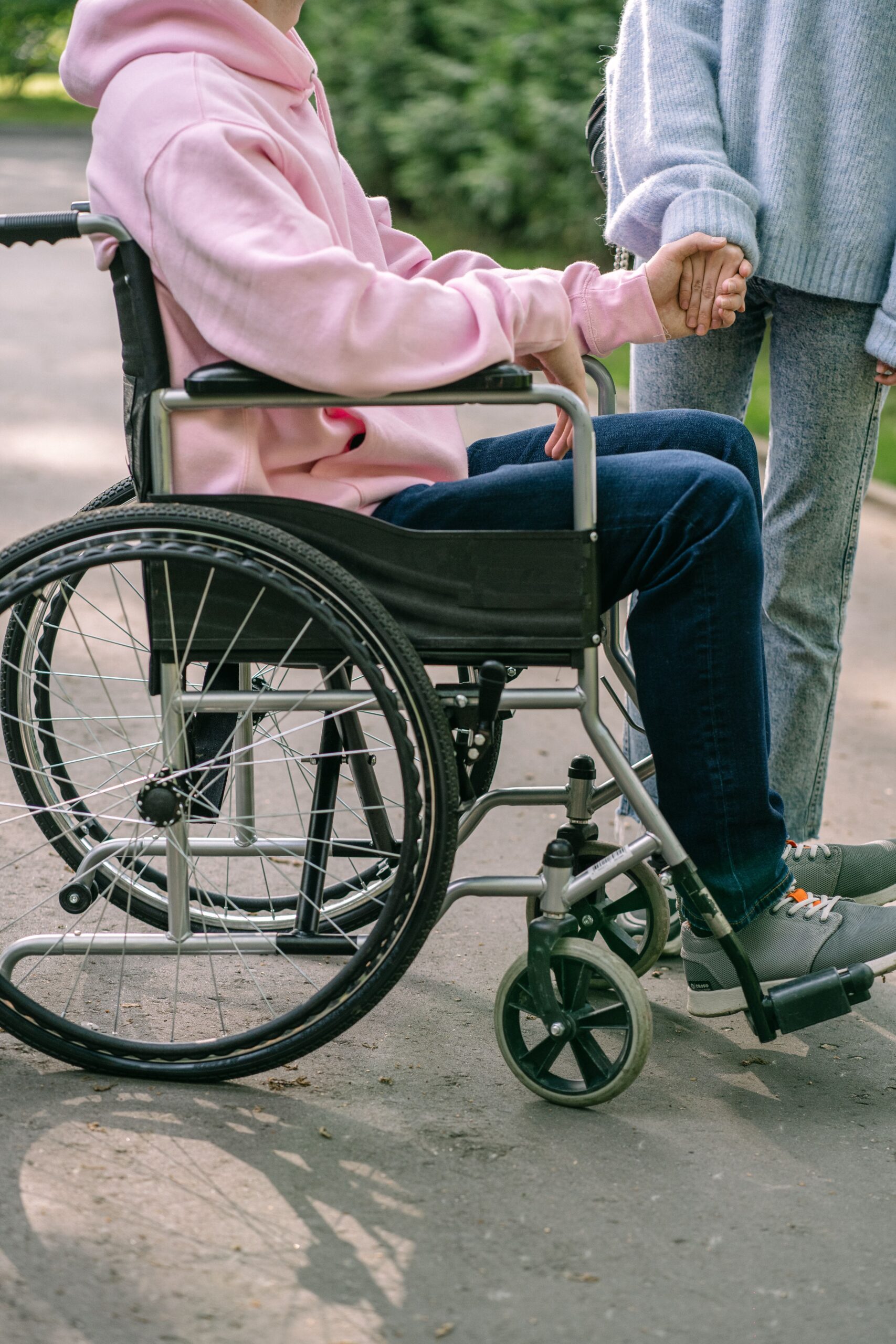 A person in a wheelchair with a companion walking beside them