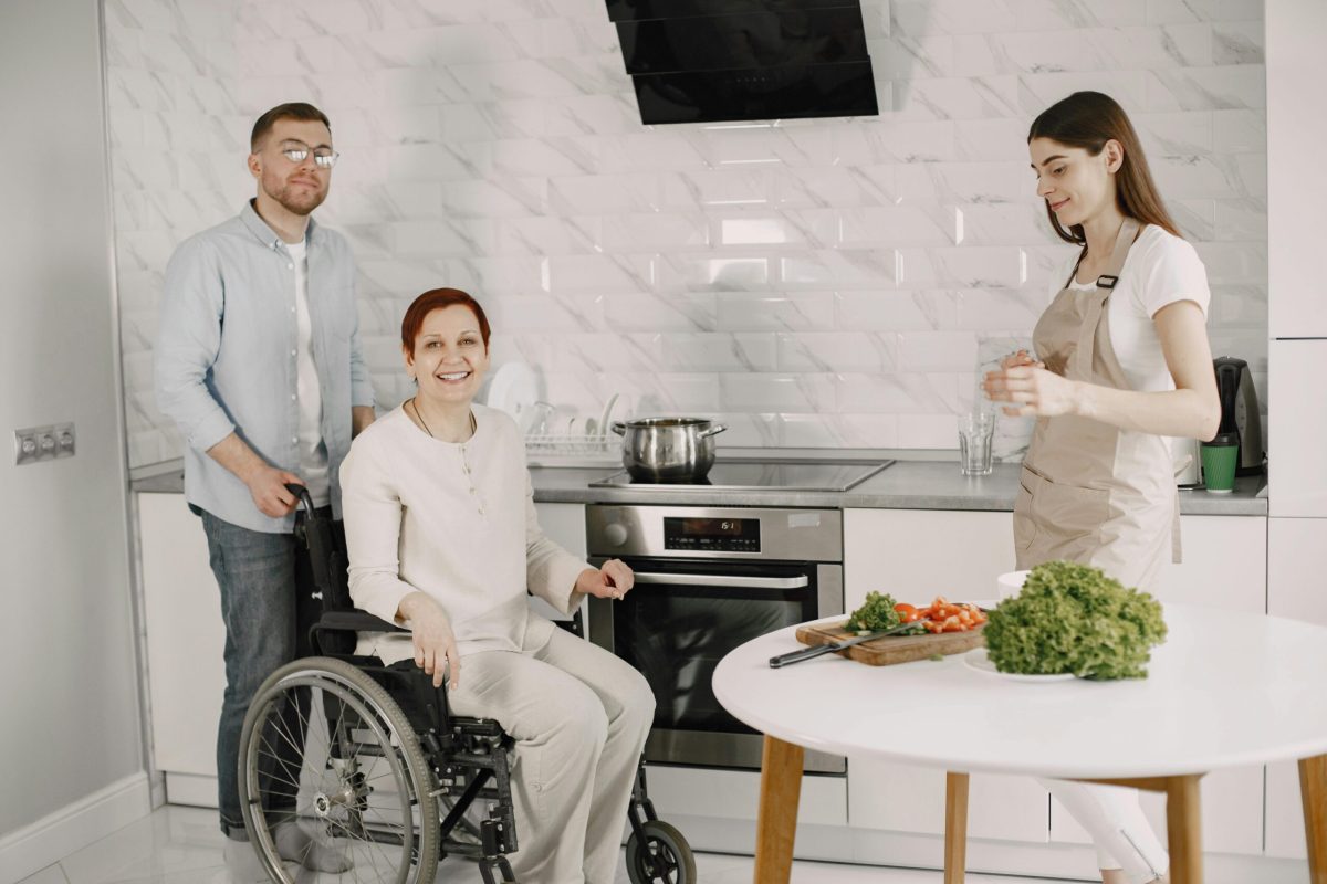 NDIS participant receiving household task support in kitchen with support worker